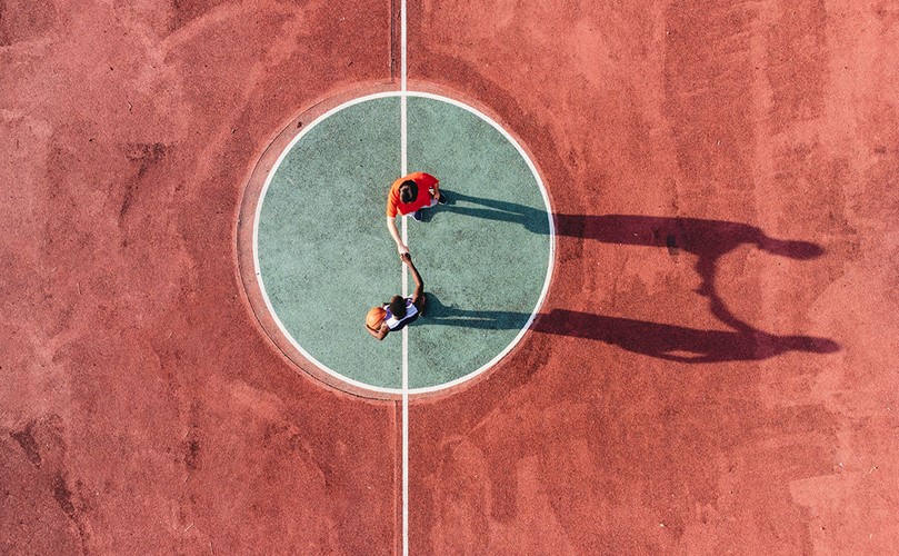 View from above of two players shaking hands in the middle of a basketball court