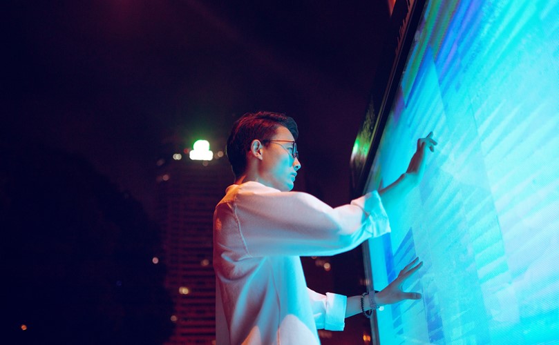 A person standing and touching a big touchscreen