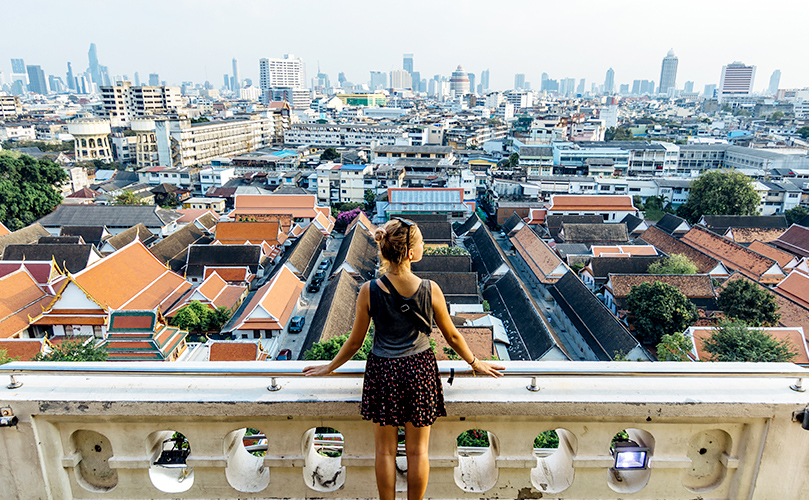 A woman on a balcony overlooking a city