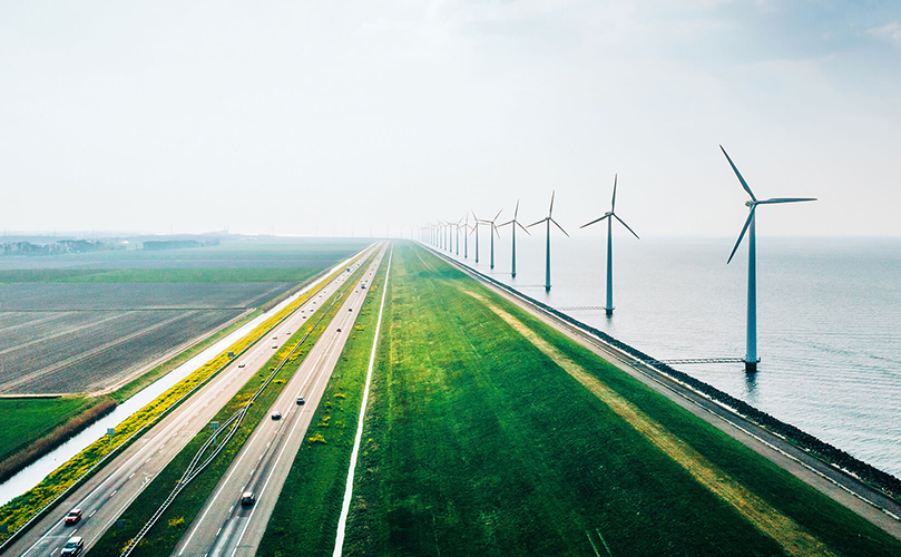 風力発電の風車が並ぶ海沿いの道の画像
